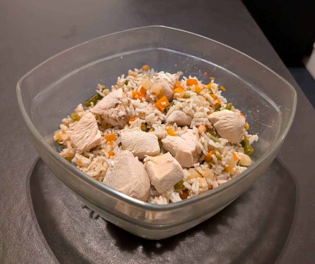 Bol de ration ménagère équilibrée contenant du riz, des morceaux de poulet et des légumes pour l'alimentation maison du Golden Retriever