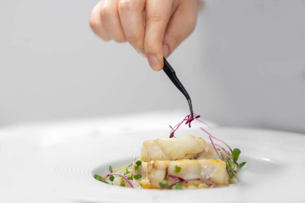 Gros plan d'un plat minutieusement dressé avec une pince, représentant de façon humoristique les recettes de ration ménagère pour chien